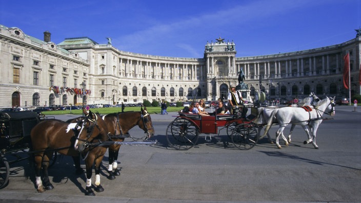 Fiaker vor der Neuen Hofburg in Wien | Bildquelle: ddp/robertharding/Hans-Peter Merten Fiaker vor der Neuen Hofburg in Wien