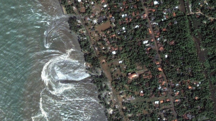 Satellitenaufnahme der Südwestküste von Sri Lanka kurz nach dem die Flutwelle des Tsunamis von Weihnachten 2004 die Küste erreicht hat. | Bildquelle: picture-alliance/dpa/dpaweb Satellitenaufnahme der Südwestküste von Sri Lanka kurz nach dem die Flutwelle des Tsunamis von Weihnachten 2004 die Küste erreicht hat.