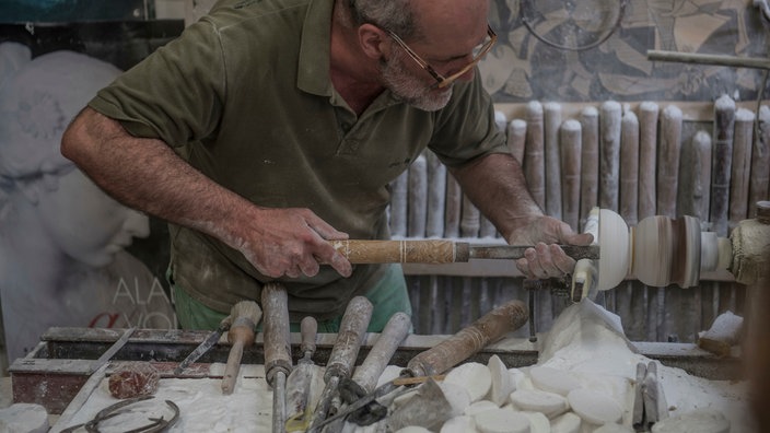 Der Alabaster-Künstler Roberto Chiti in seiner Werkstatt | Bildquelle: picture alliance / Avalon Der Alabaster-Künstler Roberto Chiti in seiner Werkstatt