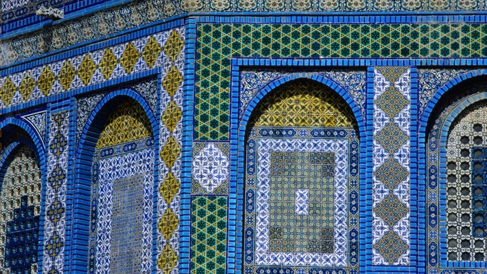 Detailaufnahme der Fassade des Felsendoms in Jerusalem. Die Fassade besteht aus unzähligen kleinen, verschieden farbigen Kacheln aus Keramik.