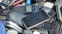 Alte Mobiltelefone liegen in einer Schubkarre
