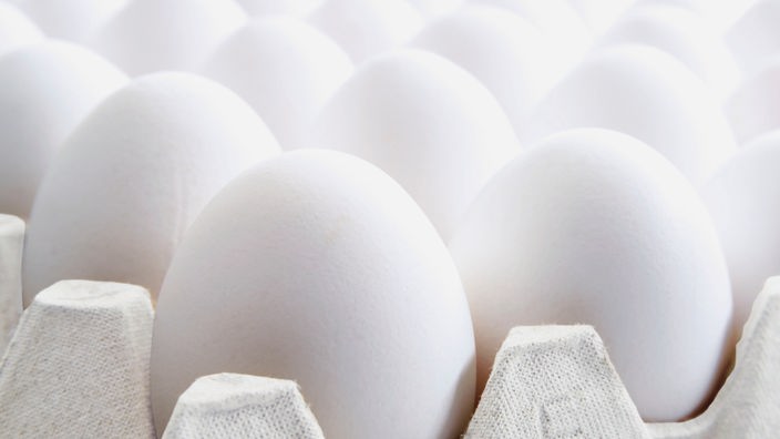 Seitliche Nahaufnahme auf weiße Eier, die in einem Eierkarton liegen.