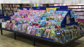 Auswahl an verpackten Kinderzeitschriften und Spielzeug in einer Buchhandlung