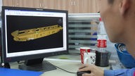 Ein Ingenieur betrachtet die Computersimulation eines Tankers.