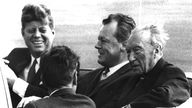 Willy Brandt sitzt in einem Auto gemeinsam mit John F. Kennedy und Bundeskanzler Konrad Adenauer