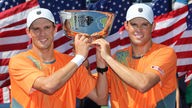 Bob und Mike Bryan halten gemeinsam die Trophäe nach dem Sieg im Herrendoppel der US Open 2012.